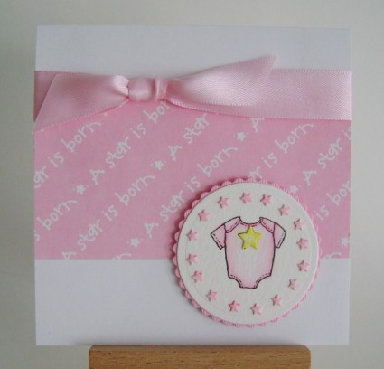 pink baby onesie with a star is born paper