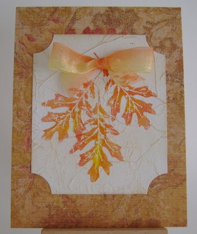 three yellow and orange oak leaves with the same colour of bow