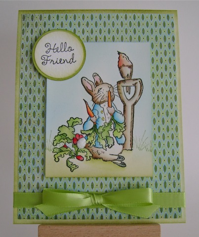 peterrabbit peter rabbit in the garden munching on carrots with a bird friend perched on a shovel next to him