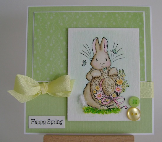 springbunny bunny holding straw hat with flowers and butterflies floating nearby