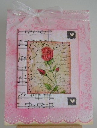 red rose in front of text, musical notes and stamped hearts in pink