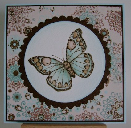 blue and brown butterfly on circle matted with brown against blue and brown designer paper