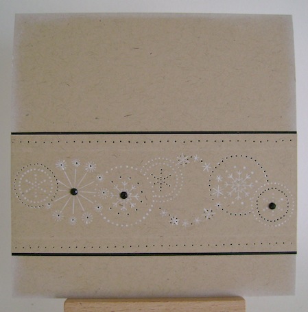 white stamped snowflakes with black trim and three black gems on kraft card