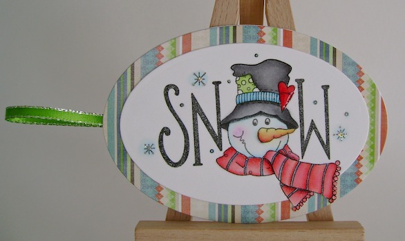 snowman gift tag with green ribbon and striped paper frame