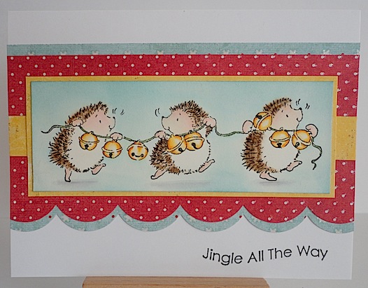 christmas card with three hedgehogs carrying a string of jingle bells