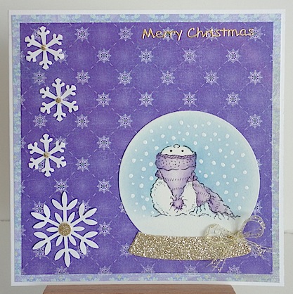 christmas card with snowman in snow globe with purple toque and purple papers with white snowflakes