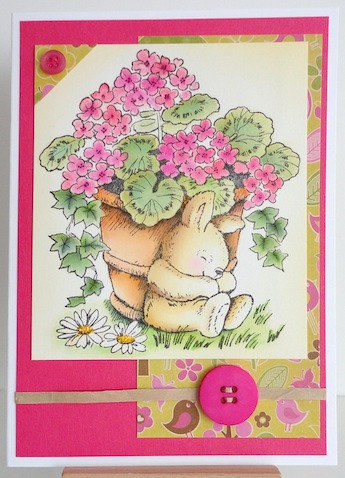 card with pot of pink geraniums and sleeping bunny next to the pot on the ground