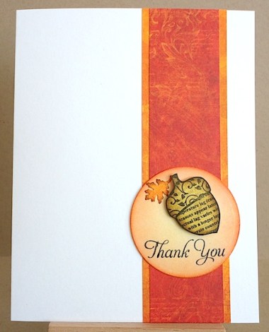 thank you card with acorn and oak leaf on a circle against a strip of orange and gold paper on a white card stock base