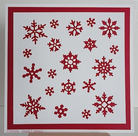 a square christmas card with red snowflakes on white background
