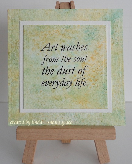 watercoloured square in blue and gold with sentiment in black