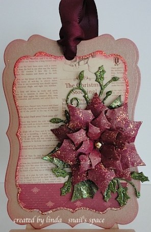 tag with poinsettia and leaves in burgundy, green, beige and glitter with a burgundy bow