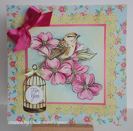 card with bird in a blooming dogwood shrub with a birdcage accent and pink ribbon bow