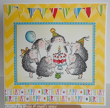 birthday card with yellow background, pennants at the top and featuring a circle of hedgehogs dancing around a birthday cake