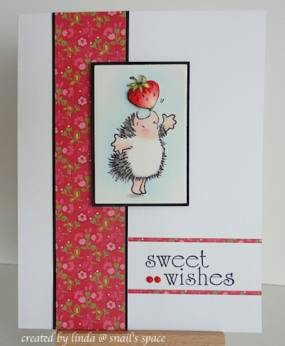 card with sweet wishes sentiment, red trim and a hedgehog balancing a strawberry on his nose