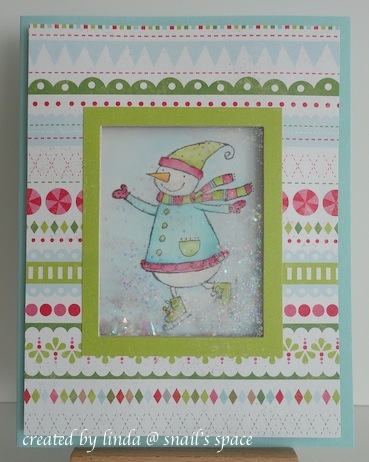 copyright by linda @ snail's space and described here for people with disabilities; christmas card in neon green, pink and blue with snowgirl behind a shaker section