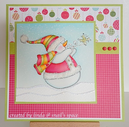 copyright linda @ snail's space and described here solely for people with disabilities; christmas card with bright red, green and blue papers with a snowman wearing a jacket, hat and scarf and a tiny green butterfly nearby