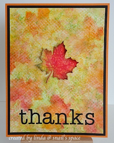 COPYRIGHT LINDA @ SNAIL'S SPACE AND DESCRIBED HERE SOLELY FOR PEOPLE WITH DISABILITIES; a card with fall colours and leaves in the background with one die cute maple leaf in the centre and black die cut letters on the bottom spelling thanks