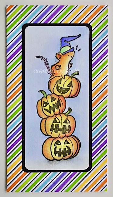 halloween mouse on top of stack of jack o lanterns